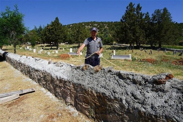 Keçiborlu ilçesine bağlı Yenitepe köyünün mezarlık duvarları yıkık bir durumdaydı.
